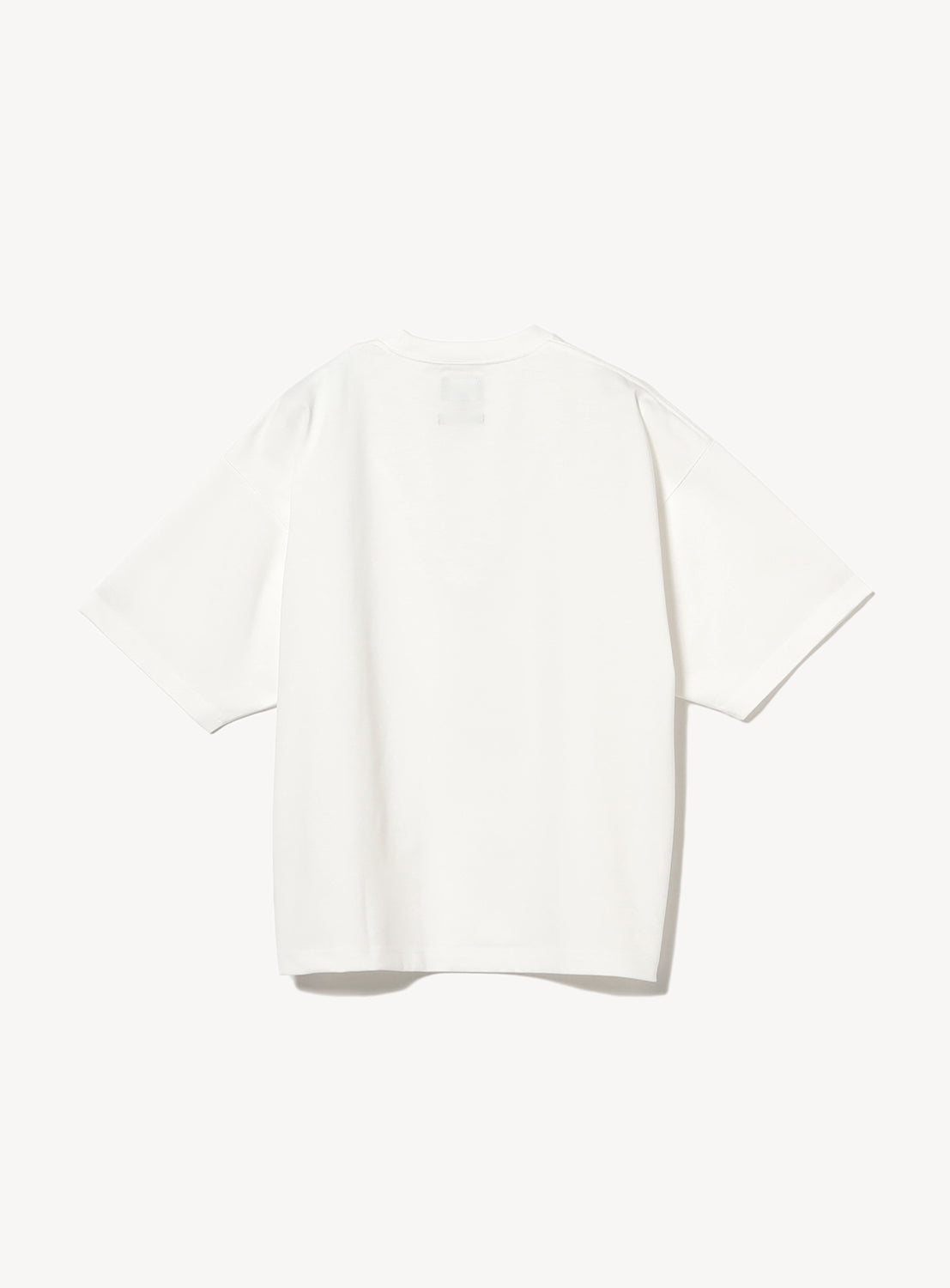 Back view of a plain white oversized T-shirt with short sleeves, displayed against a white background. The T-shirt has a minimal design with no visible branding or graphics on the back.