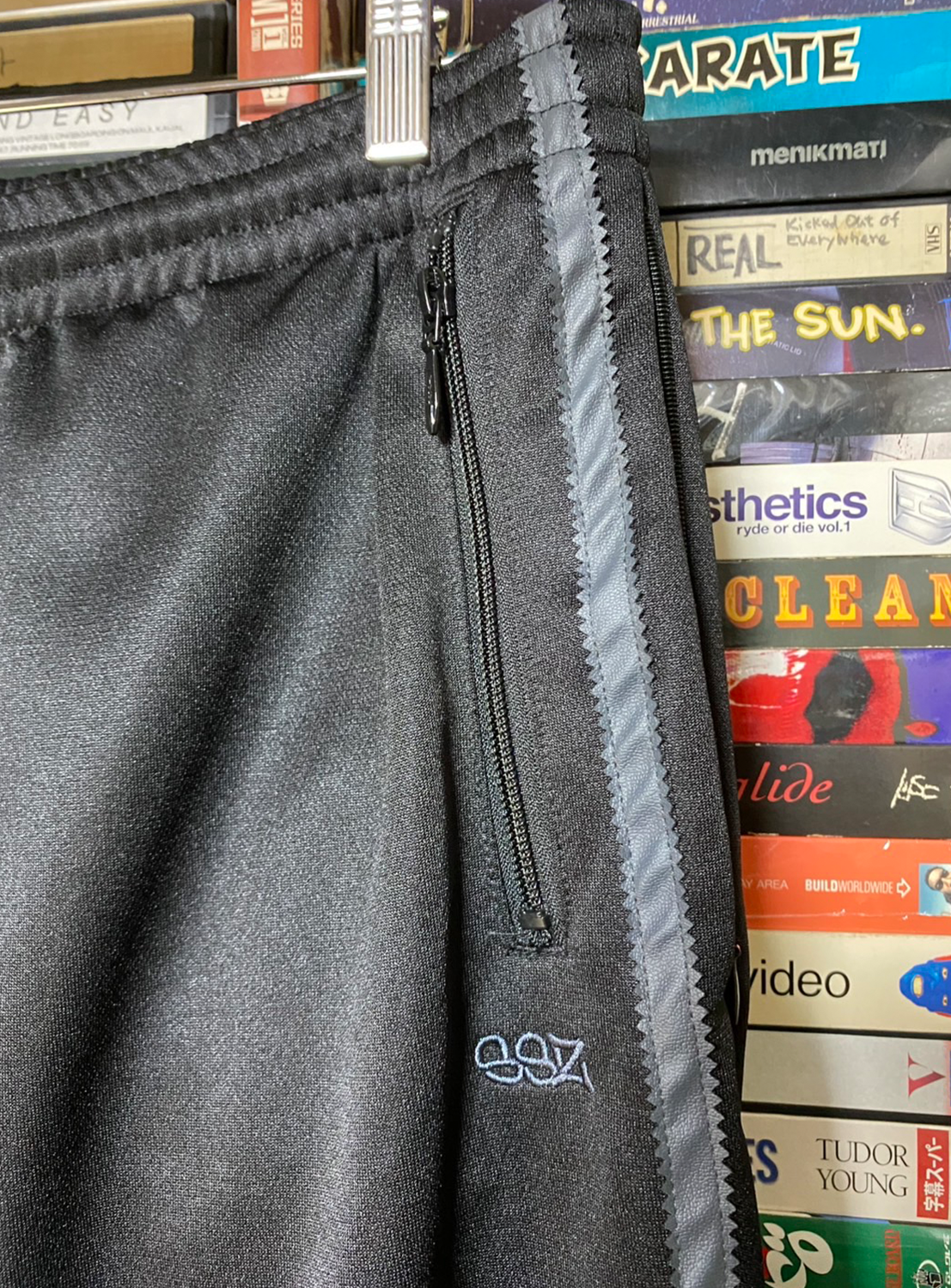 Close up of waistband, pocket with zipper clothing and SSZ embroidered logo.