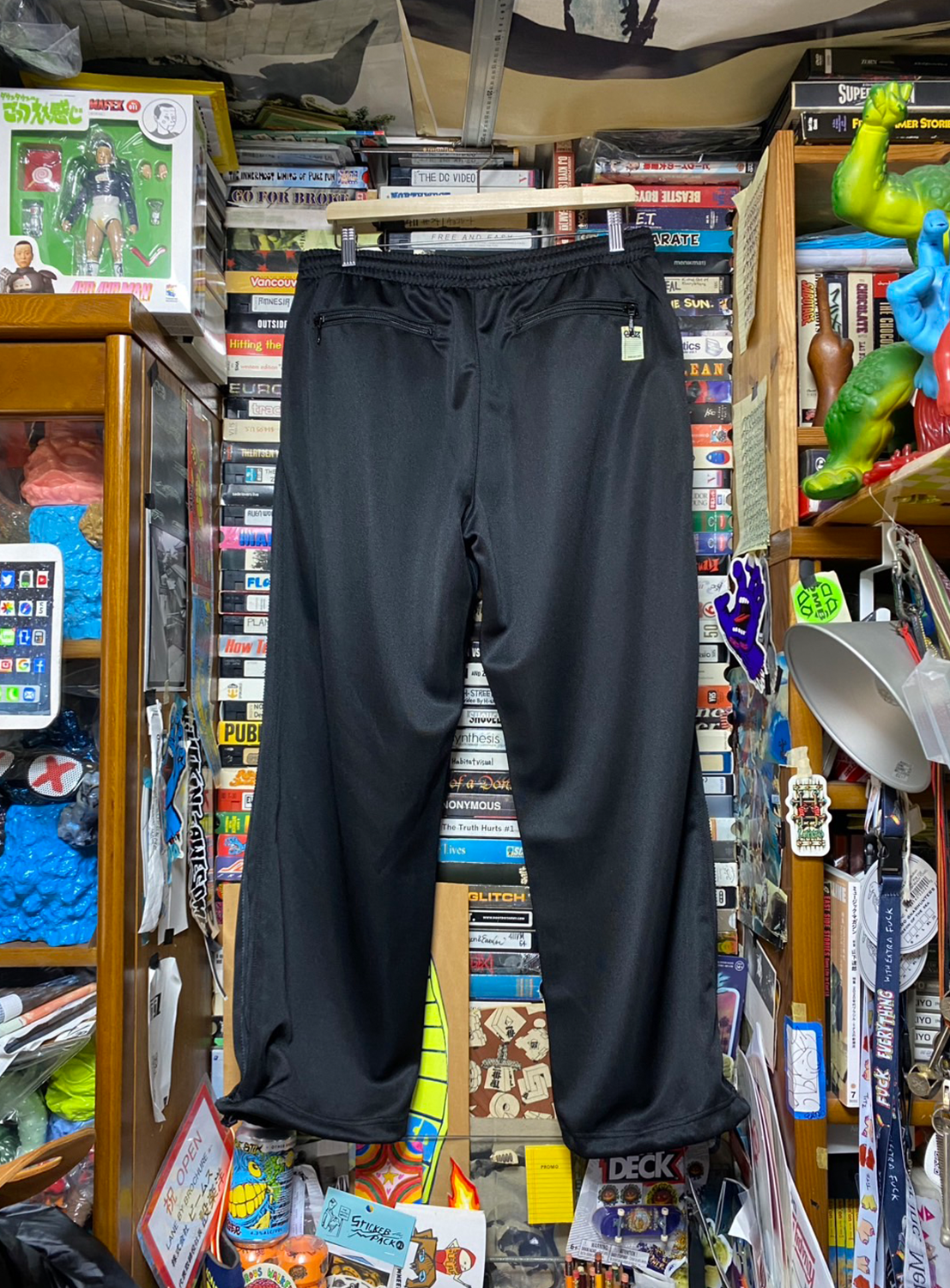 Back of black track pants, highlighting the full silhouette and effortless utility.