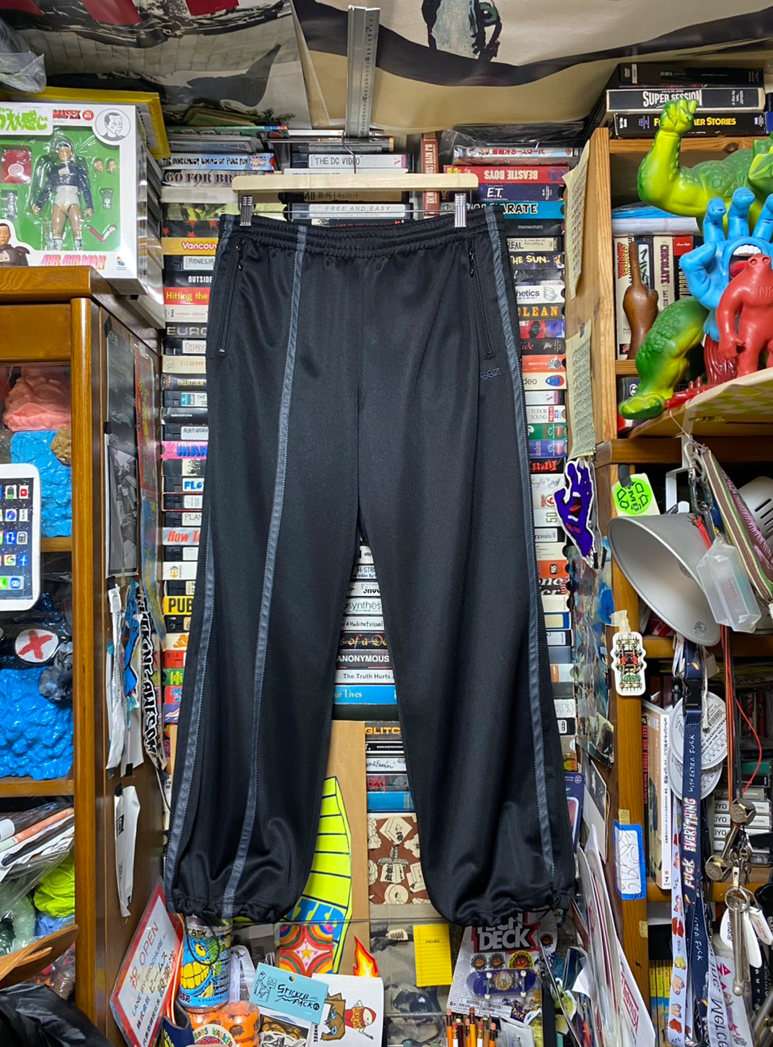 Black track pants with distinctive side line details, embodying SSZ's understated design language.
