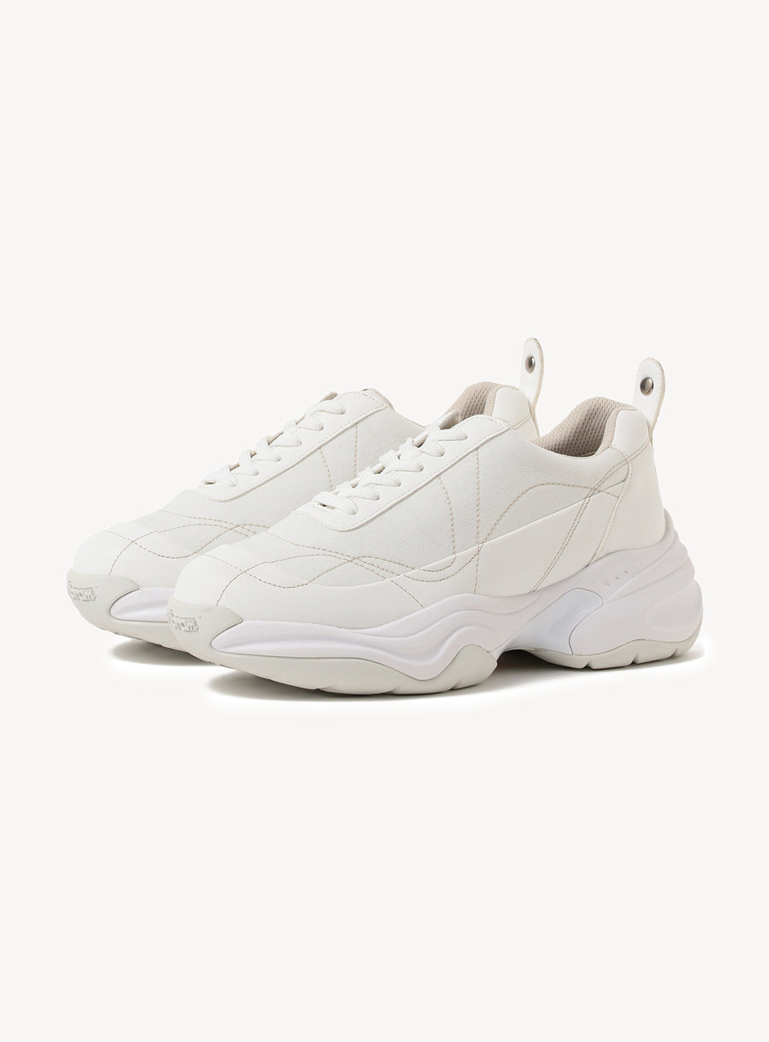 Pair of white chunky sneakers with a thick sole and white laces.