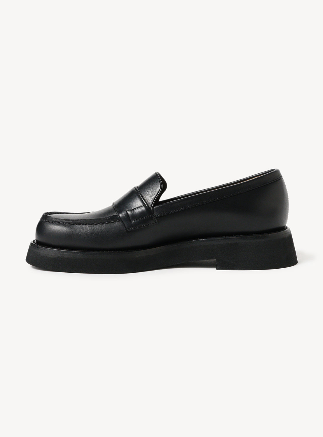 Side view of black leather loafers.