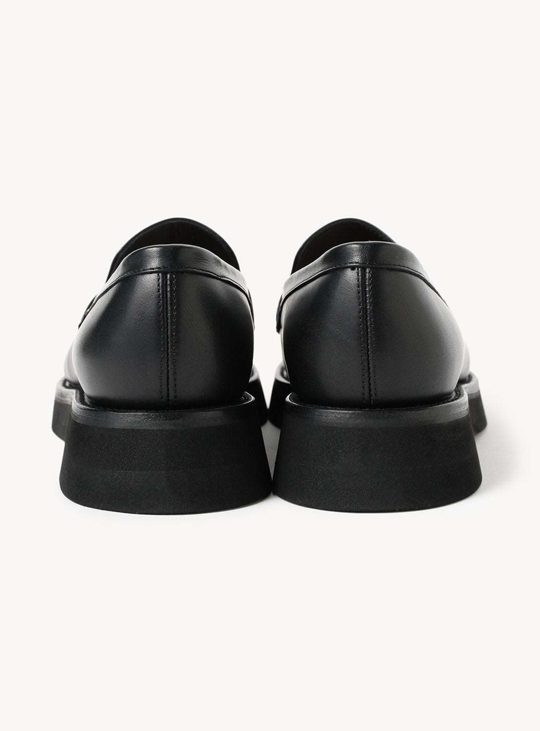 Back view of black leather loafers and the chunky sole.