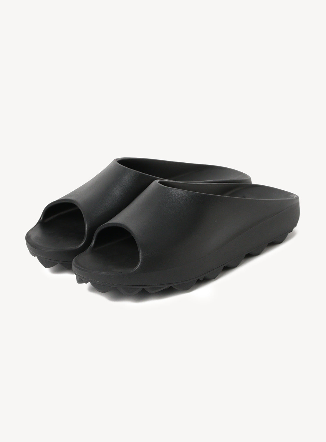 Pair of black slip-on slides with a thick, textured sole.