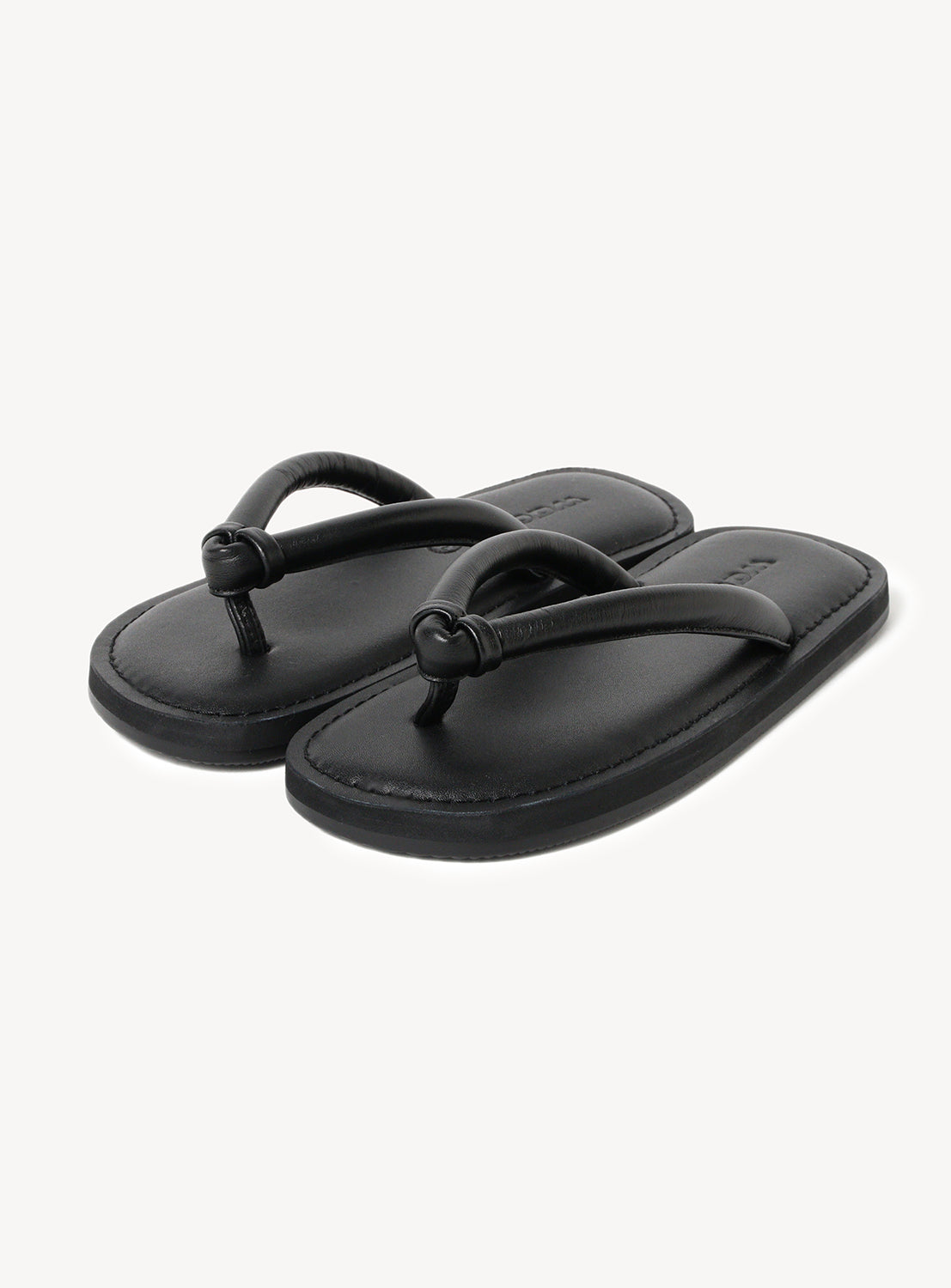 A pair of black flipflops with a thick thong strap and flat sole.