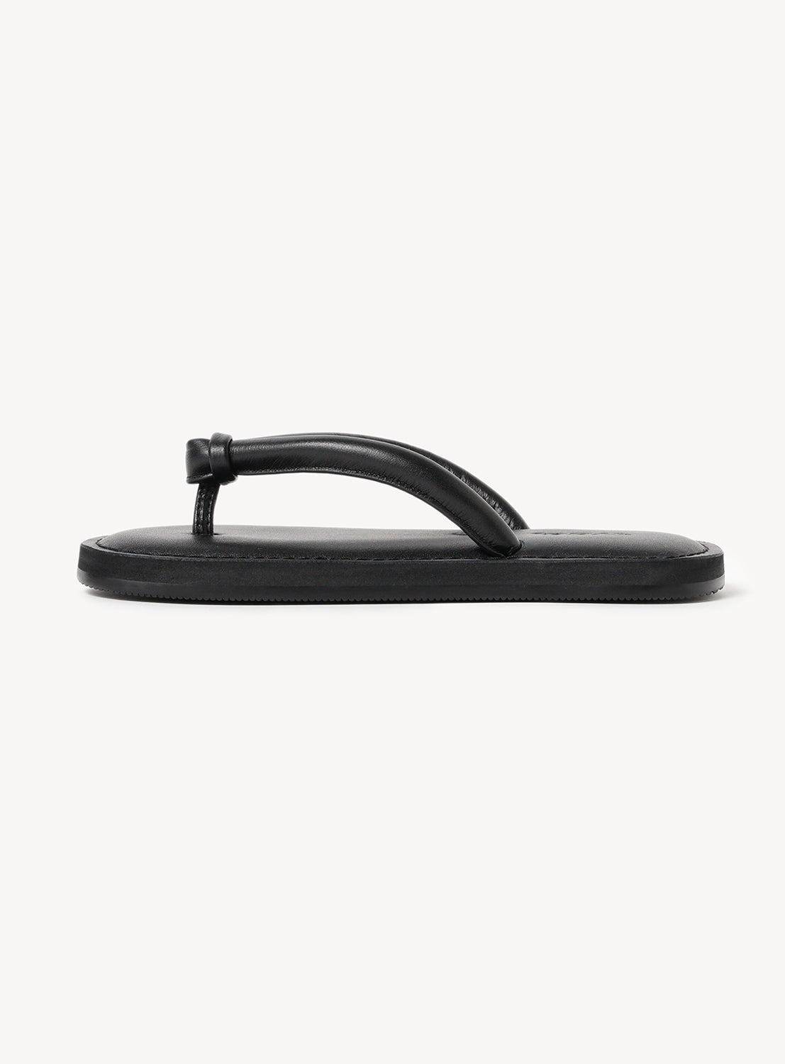 Side view of black flipflops with a thick thong strap and flat sole.
