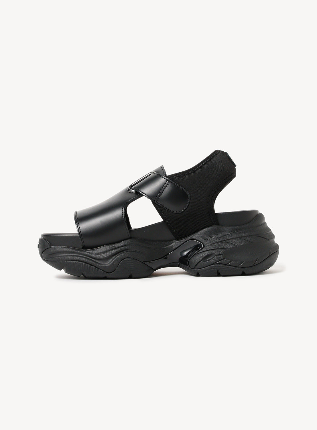 Single black chunky sole sandal, side view, highlighting its thick sole and adjustable straps.