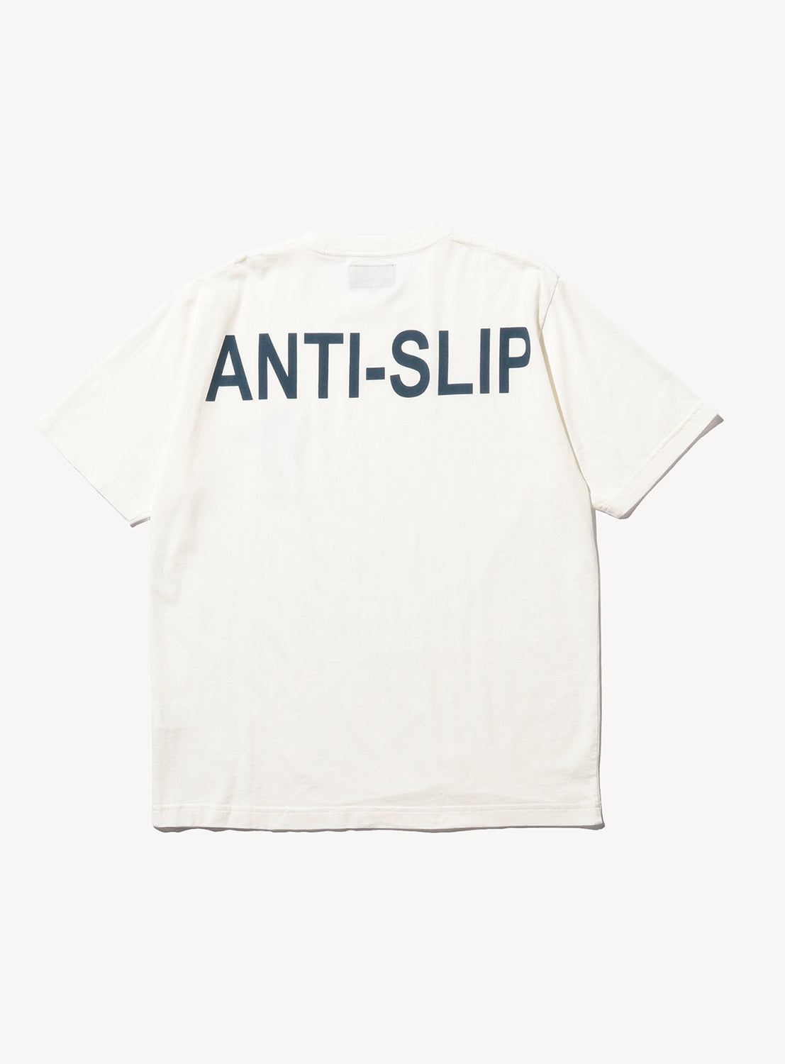 Back of white t-shirt with the text, "ANTI-SLIP" in navy blue.