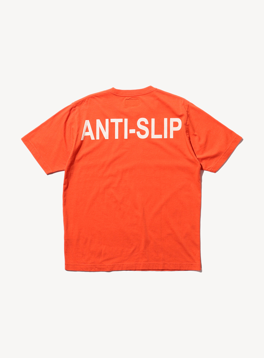 Back of orange t-shirt with large text across the shoulders that says, "ANTI-SLLIP."
