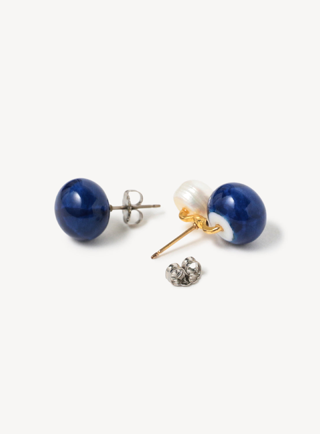 Pair of blue spherical earrings, one with a freshwater pearl attached.