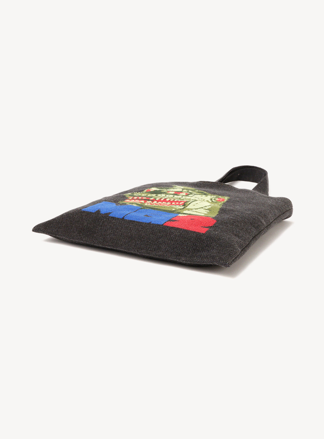 The Horinouchi Sweater Bag by Amimono Horinouchi is a black knit tote featuring a vibrant green monster face and bold red and blue text near the bottom, part of the playful Knitting☆Horinouchi collection.