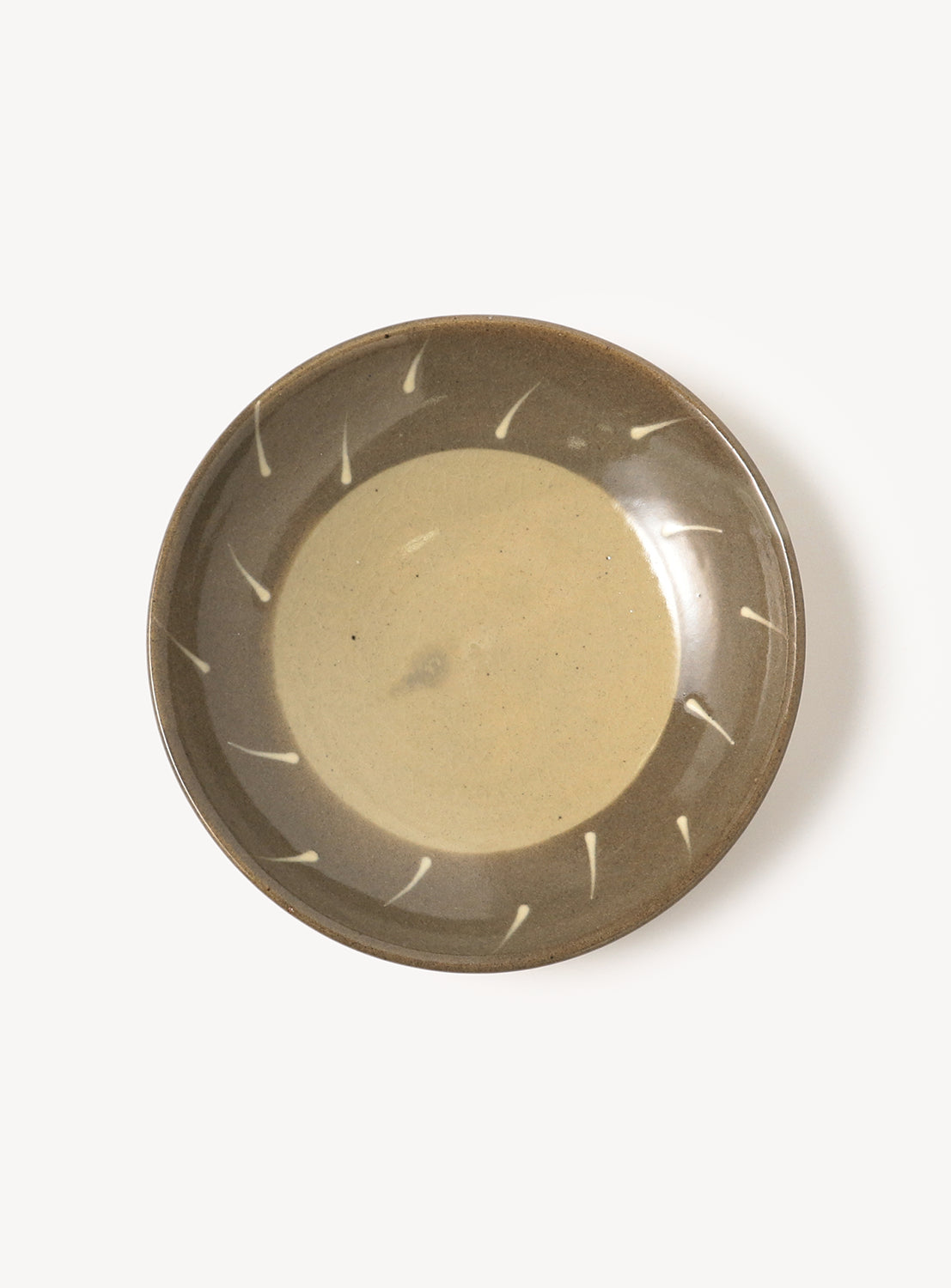 Birdseye view of beige and brown serving plate with a simple white design.