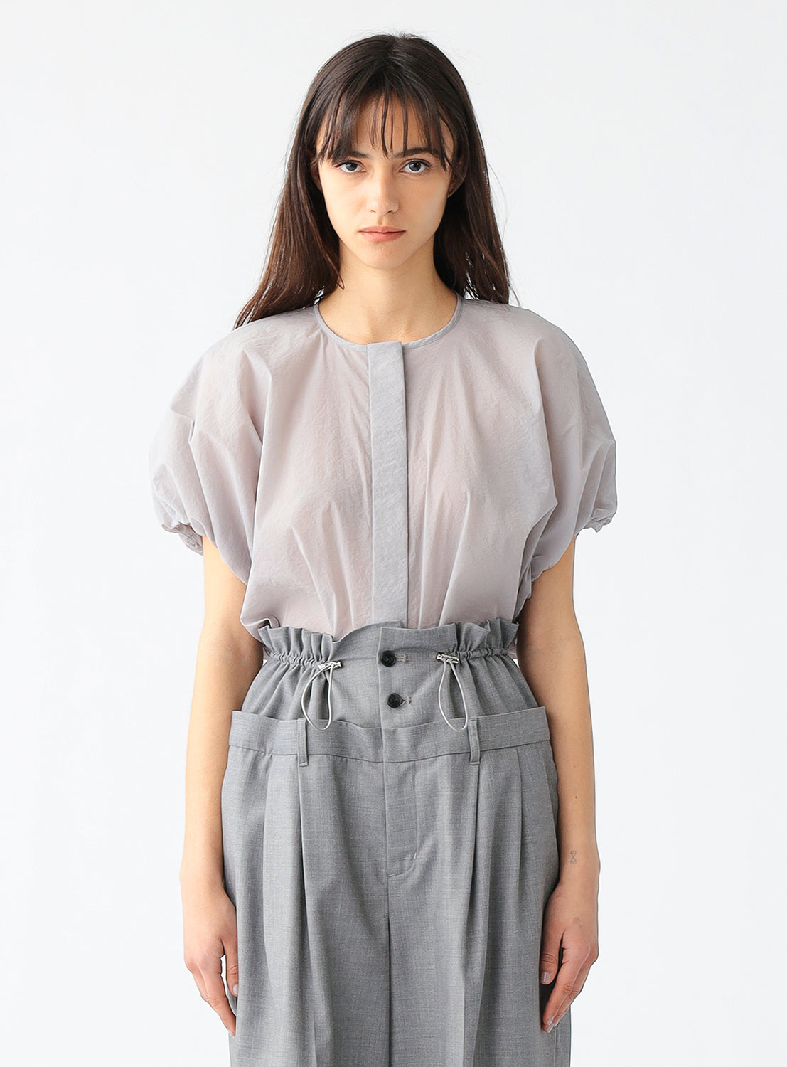 Model wearing a light grey blouse, showcasing the voluminous silhouette and softly gathered sleeves.