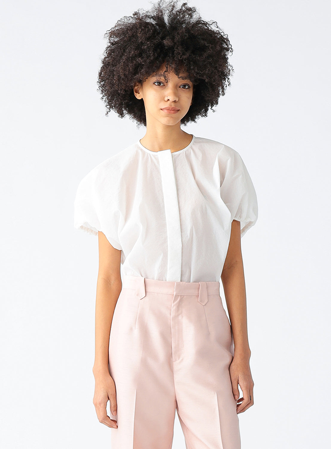 Model wearing a white blouse, showcasing the voluminous silhouette and softly gathered sleeves.