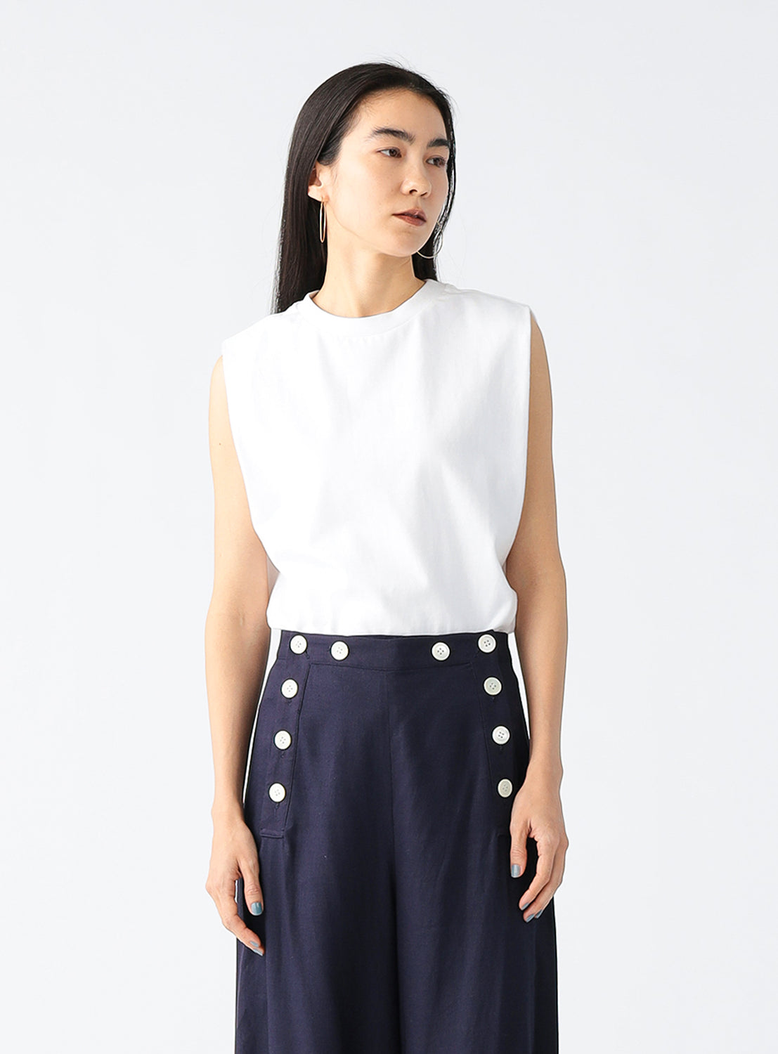 Model wearing a plain white sleeveless top.