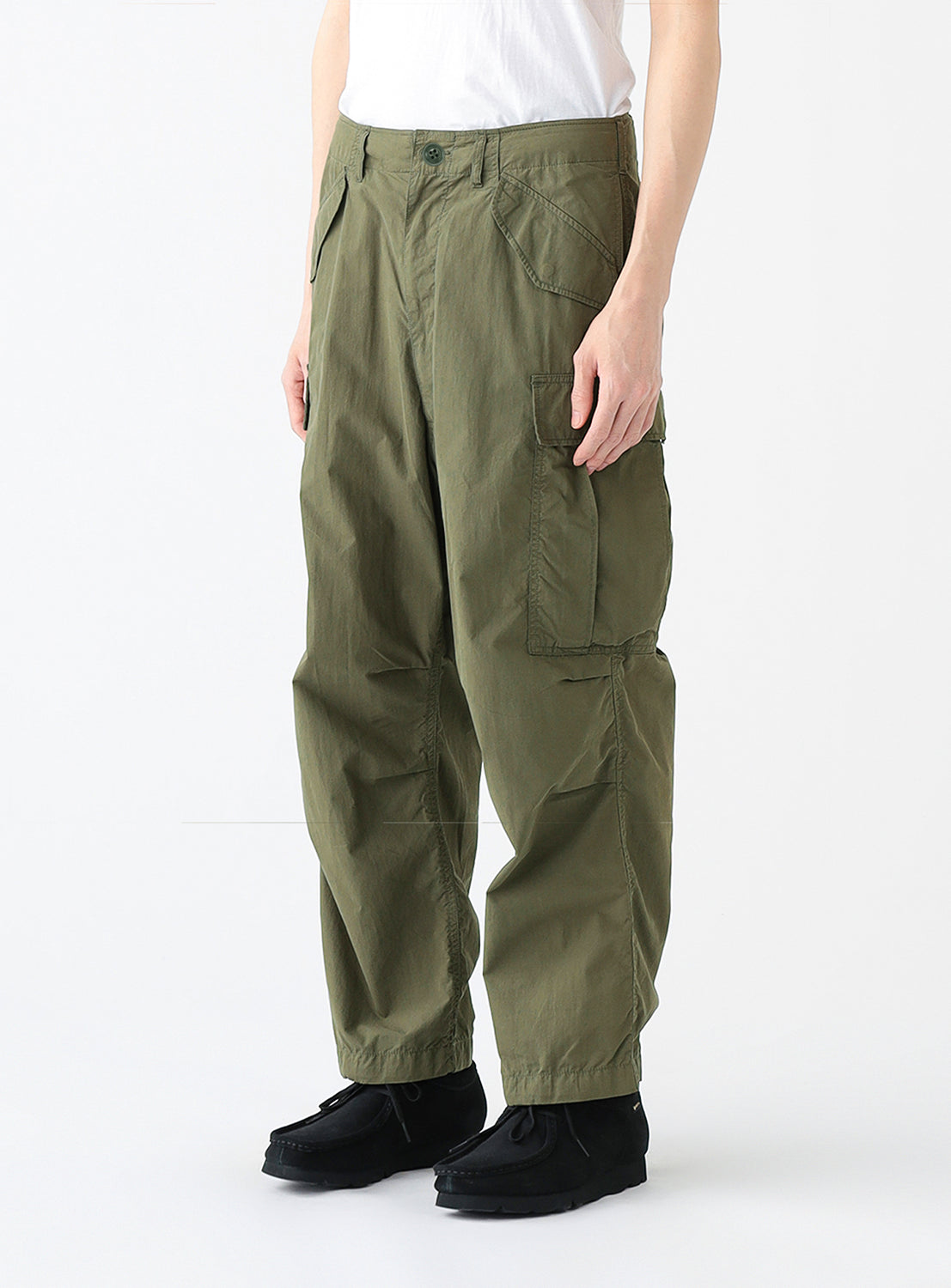 Close up of a model wearing a pair of olive green cargo pants with multiple pockets.
