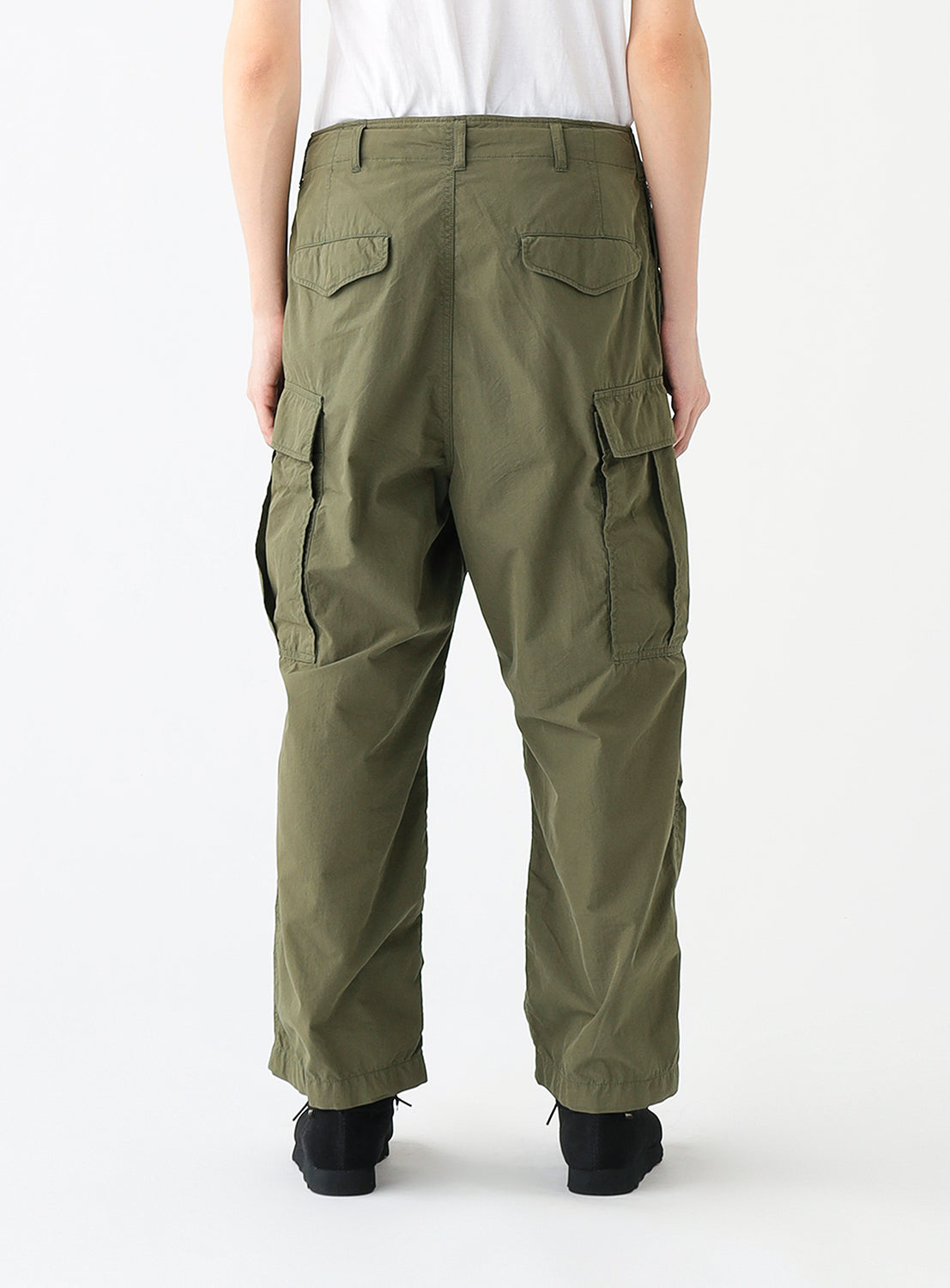 Close up back view of a model wearing a pair of olive green cargo pants with multiple pockets.