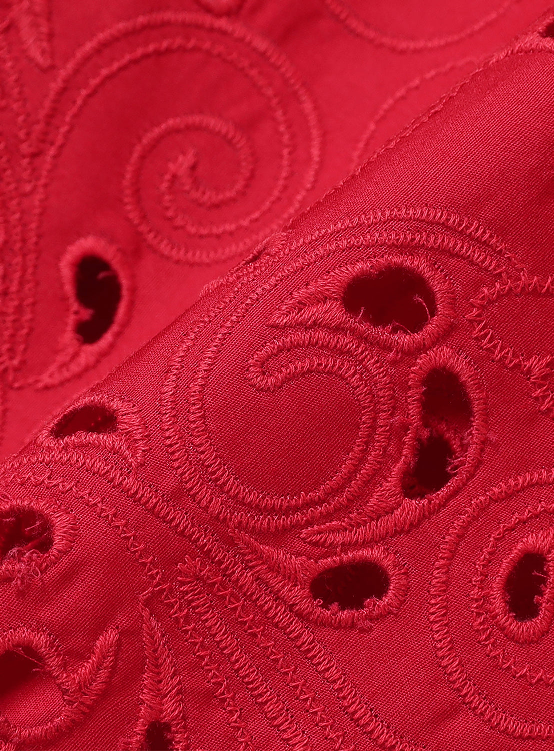 Close-up of the red blouse fabric, highlighting the intricate cutwork embroidery for an elegant and relaxed shape.