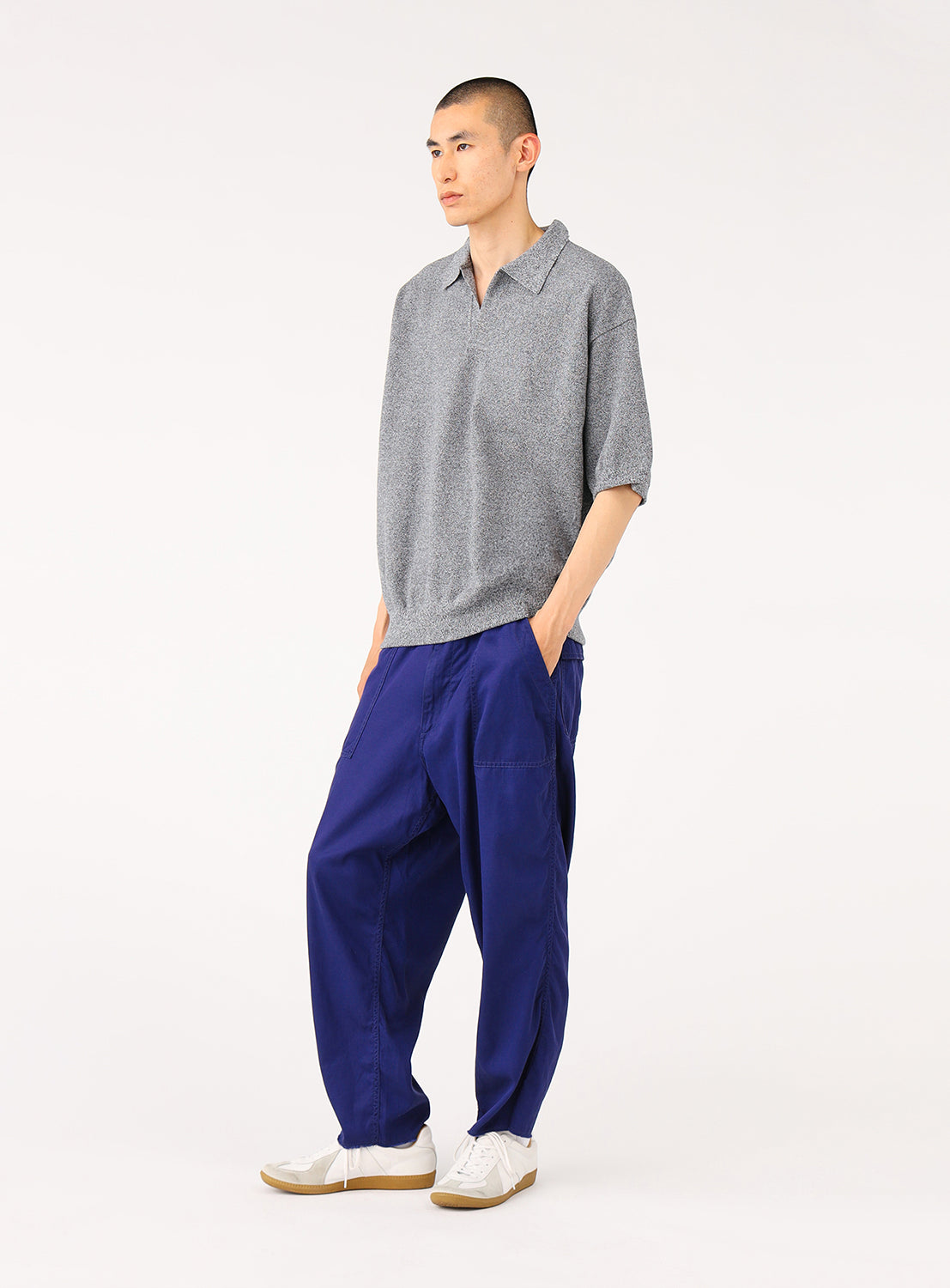 Side view of a model wearing navy blue loose-fit cargo pants, emphasizing the roomy fit and utilitarian-inspired style.