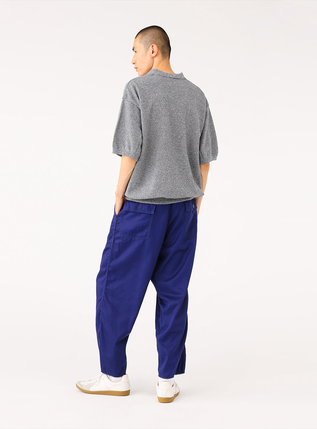Back view of a model wearing navy blue loose-fit cargo pants, highlighting the relaxed leg and rear pocket details.