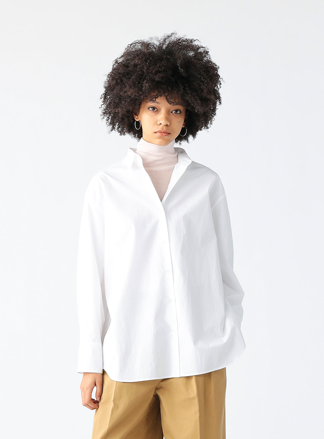 Model wearing the oversizes white button down shirt.