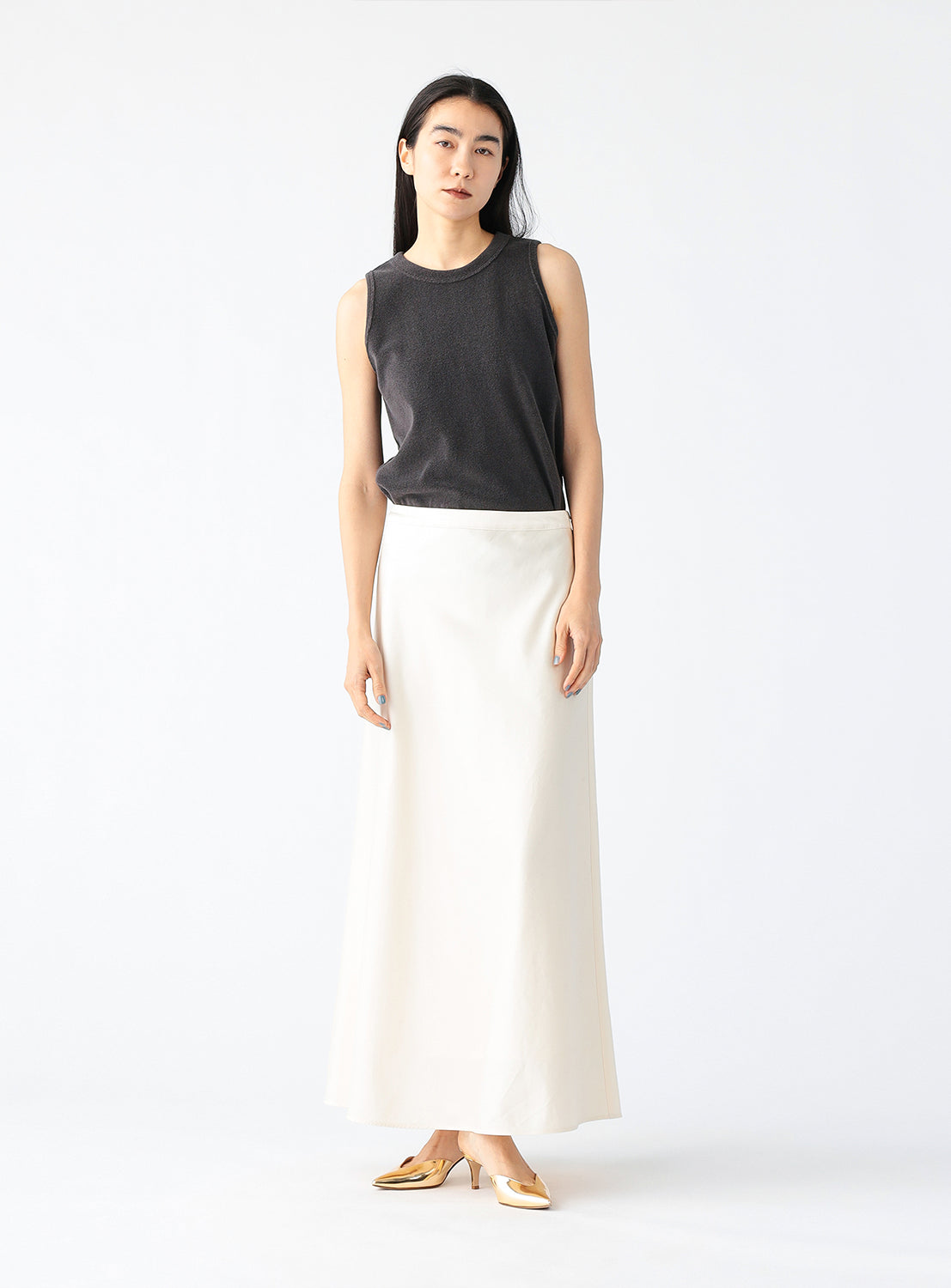 Model wearing a white maxi skirt, styled.