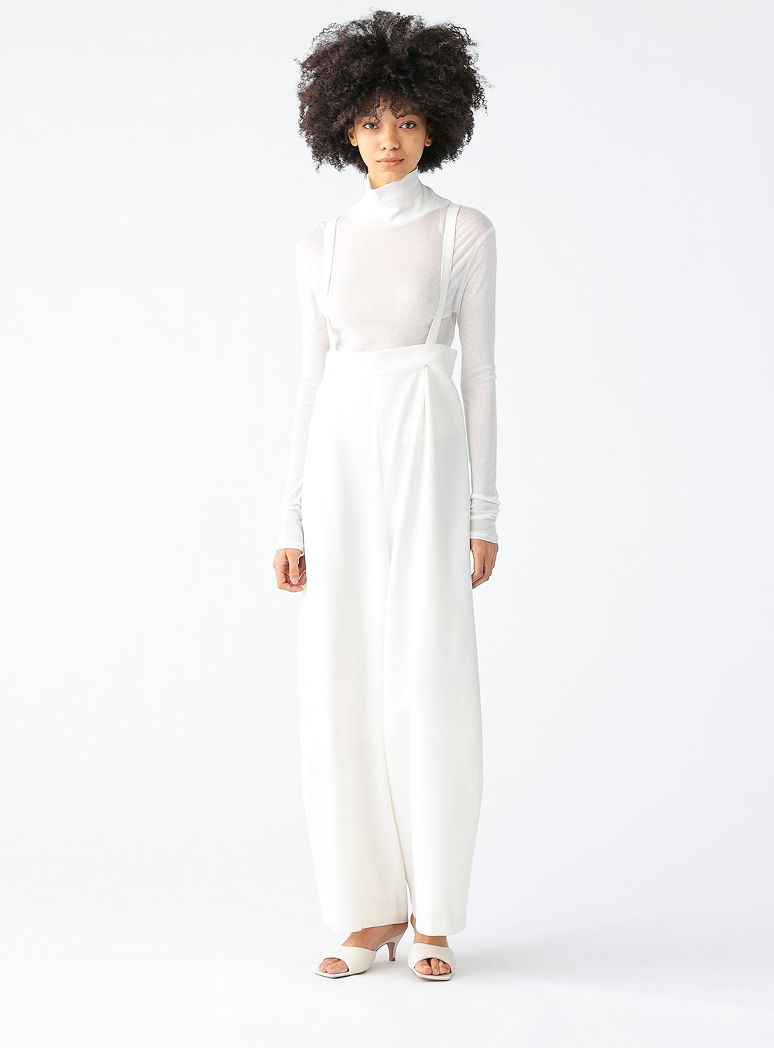 A model wearing a white sheer long sleeve.