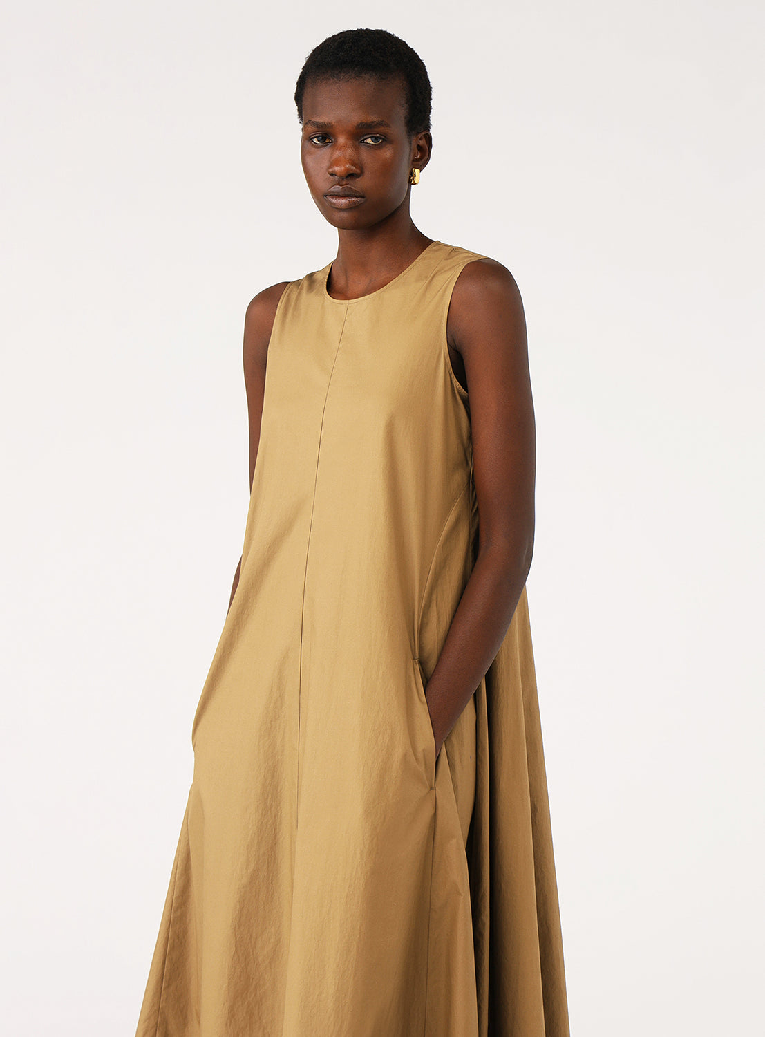 Close up of a model showcasing a the khaki maxi dress with a relaxed fit and pockets.