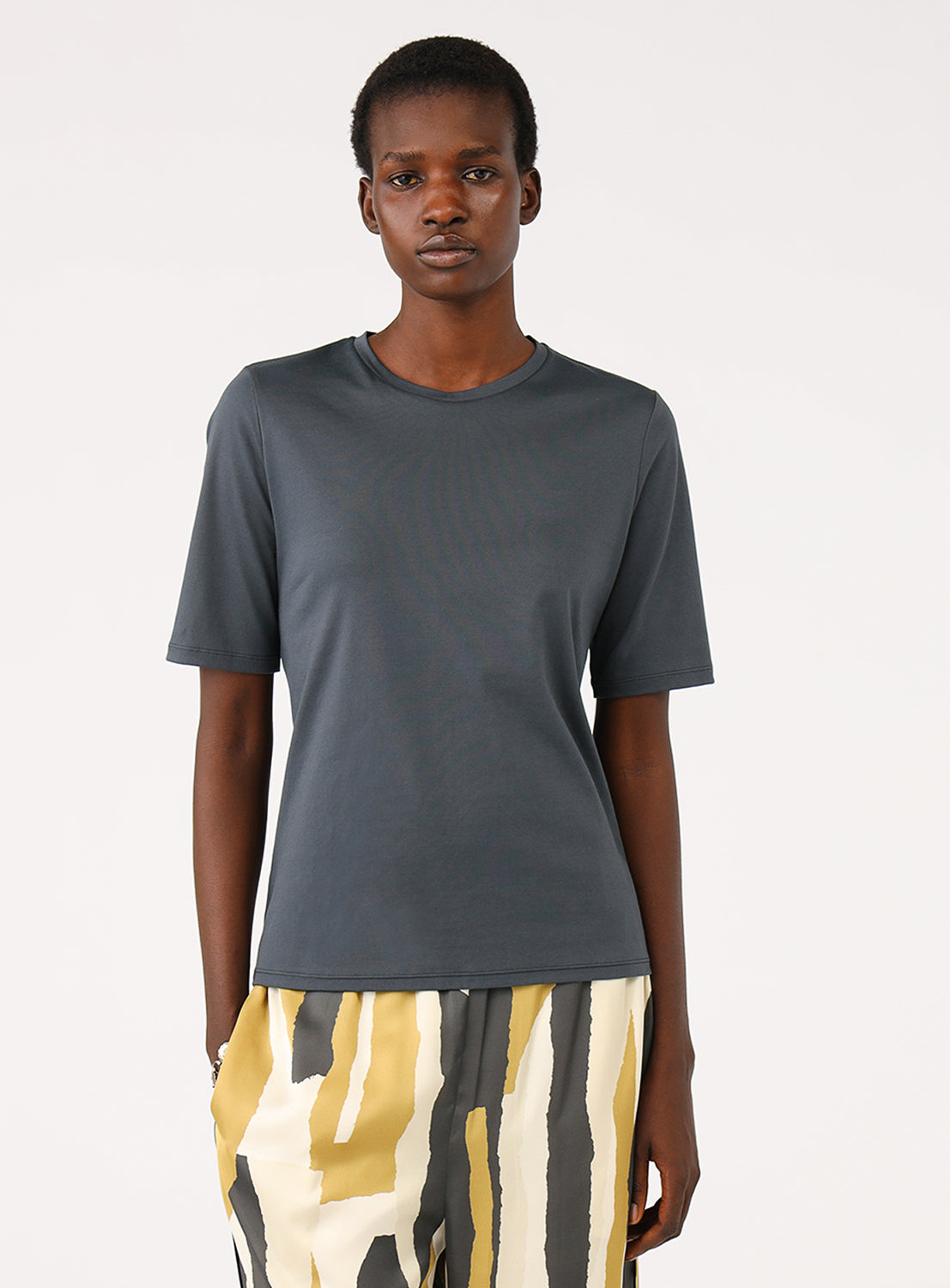 Close-up of a model wearing a charcoal colored t-shirt, styled.