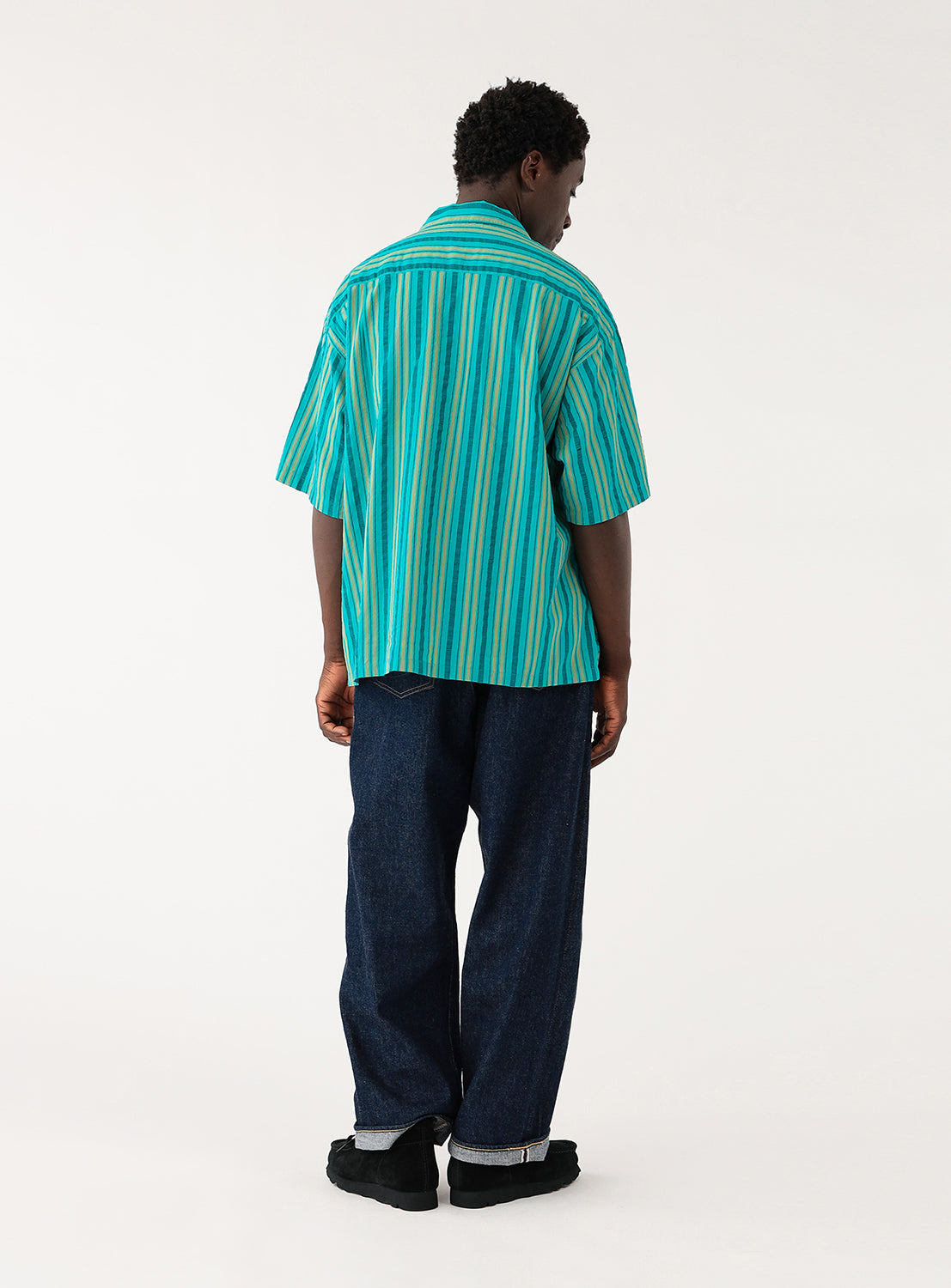 Dobby Stripe Open Collar Shirt teal BEAMS. Model wearing a teal shirt with green stripes and black pants, back view, showcasing the vibrant striped design.