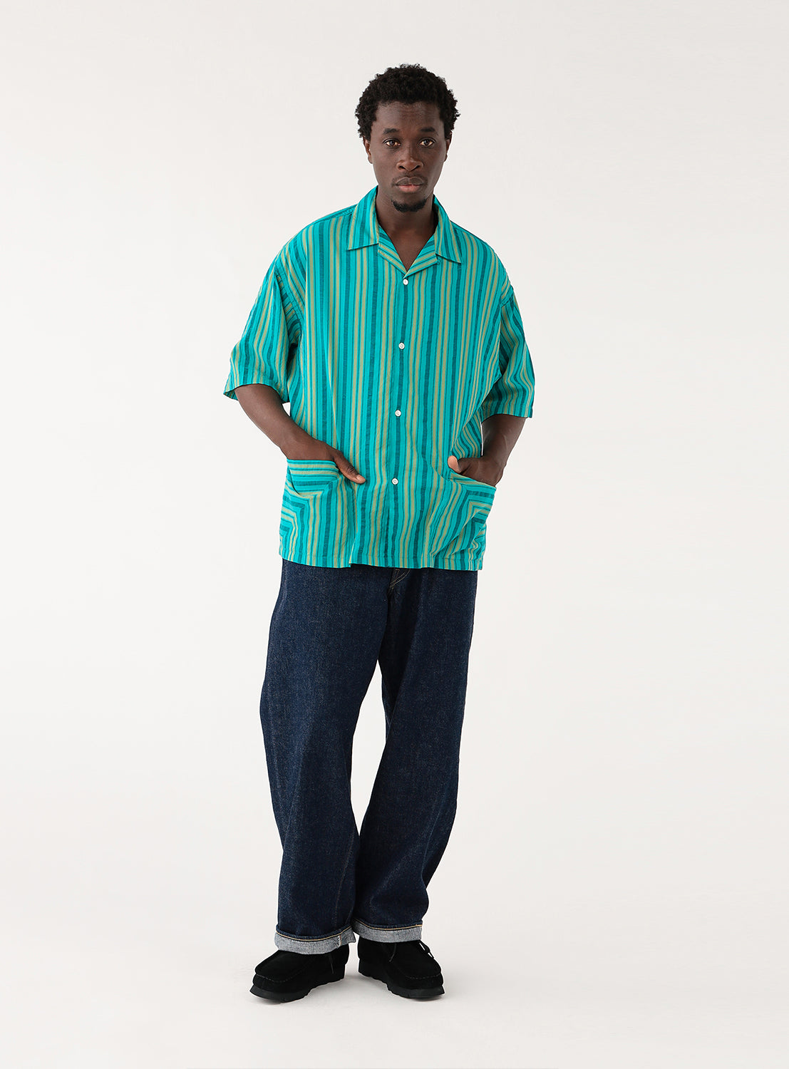 Dobby Stripe Open Collar Shirt teal BEAMS. Model wearing a teal shirt with green stripes and black pants, side view, emphasizing the relaxed silhouette.