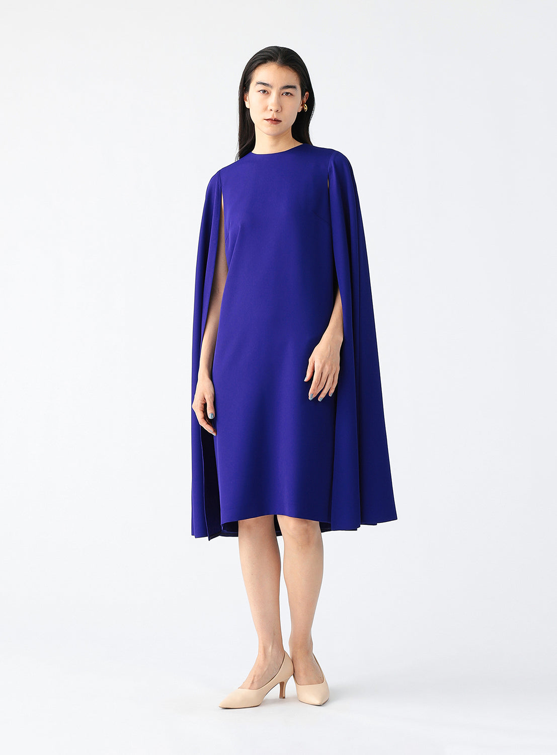 Full body view of a model wearing a blue cape dress.