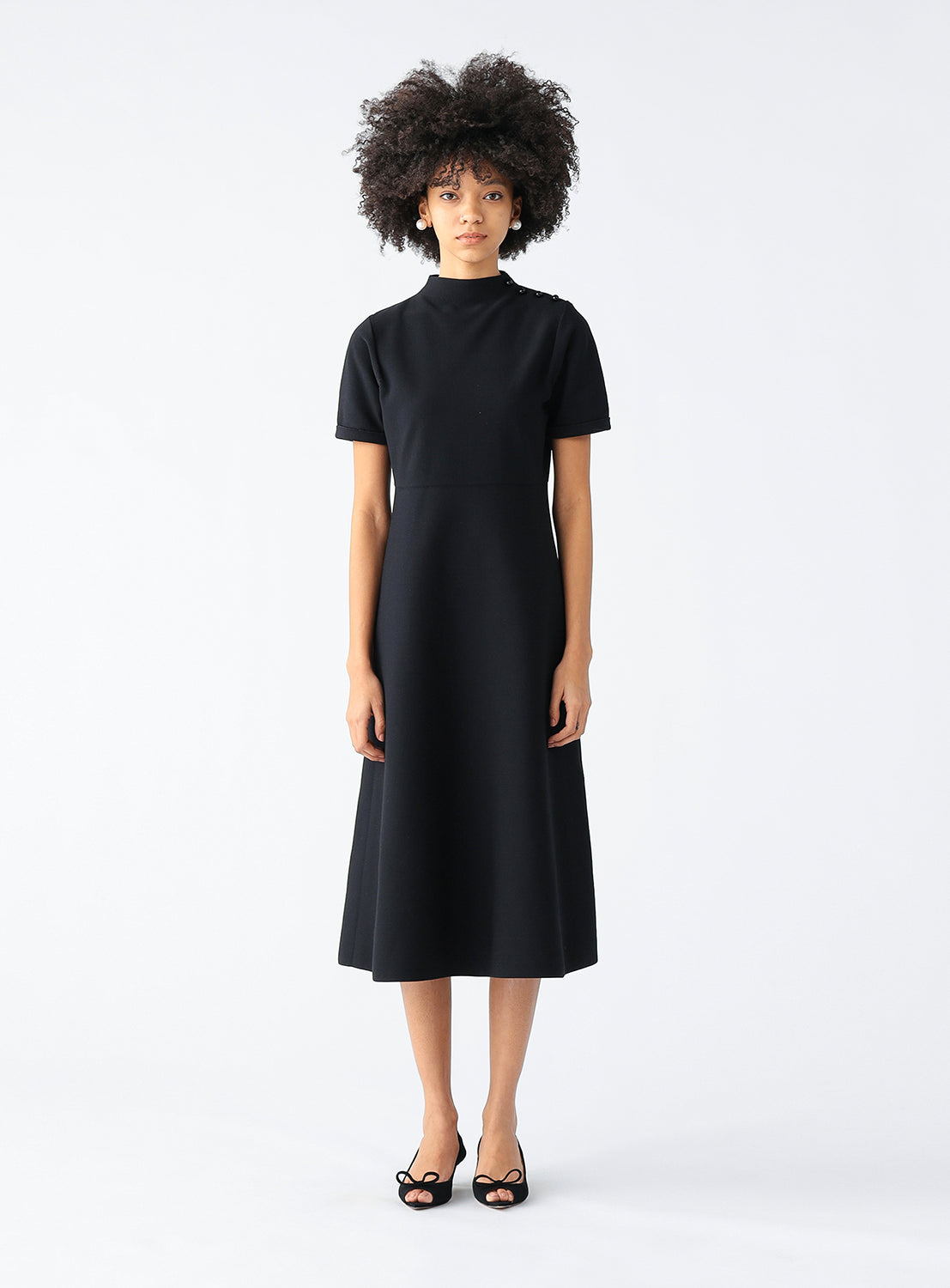 Model wearing a black fit and flare knit dress.