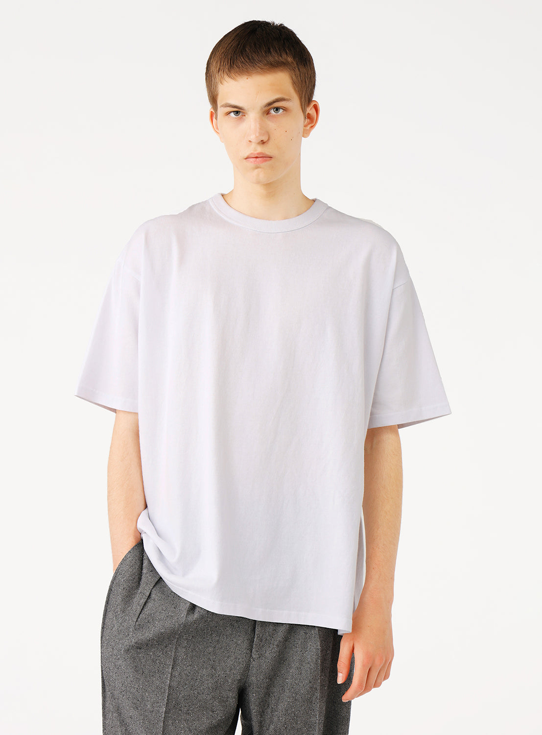 Front view of a man modeling a relaxed white oversized t-shirt.