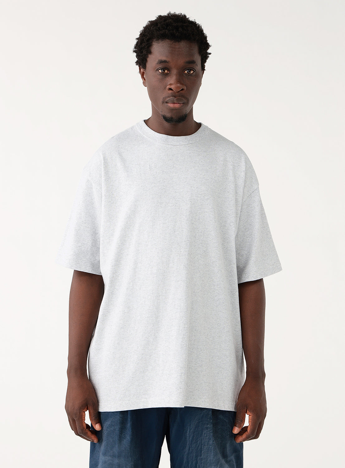 Front view of a man modeling a relaxed ash grey oversized t-shirt.