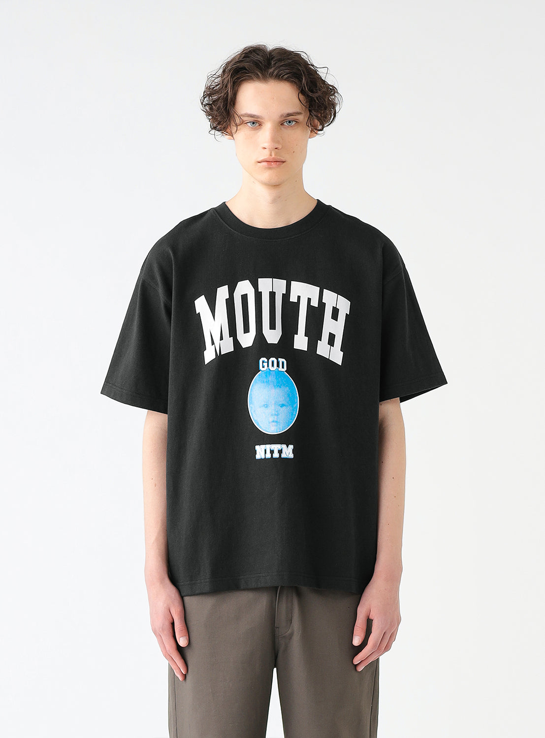 Model wearing black short-sleeved graphic t-shirt with the text 'MOUTH' and a graphic print in the center.