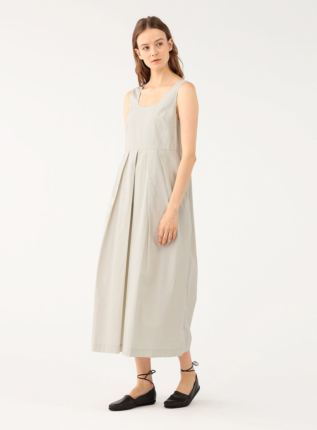 Model wearing a cream 100% cotton wide-leg jumpsuit, front view, displaying its flowy silhouette.