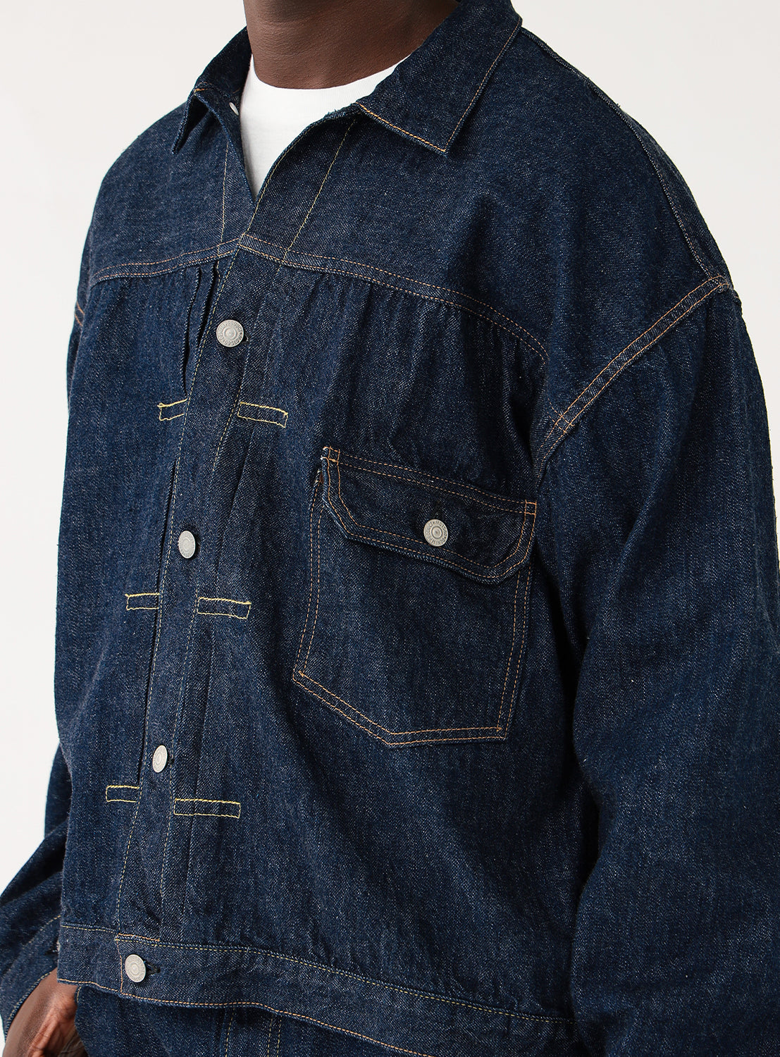 Close up of orSlow x BEAMS JAPAN exclusive Type 1 denim jacket – lightweight selvedge Japanese denim, heritage workwear design, dark indigo blue with metal buttons and asymmetrical chest pocket.