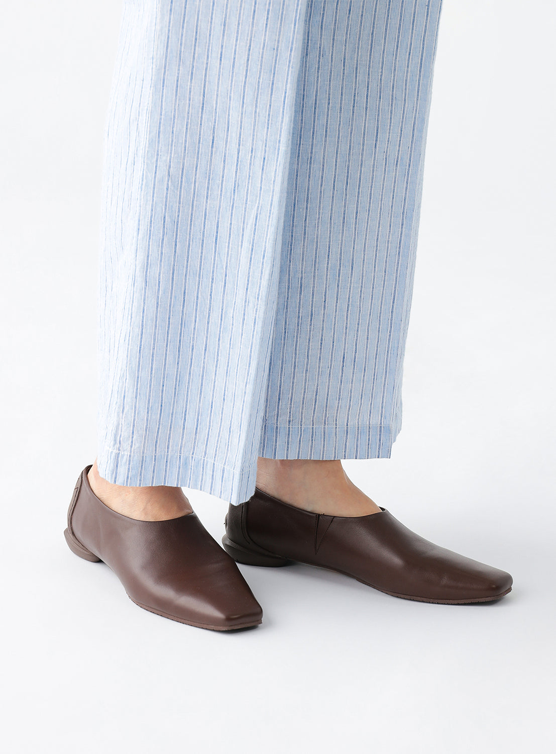 Model wearing the brown square flats.