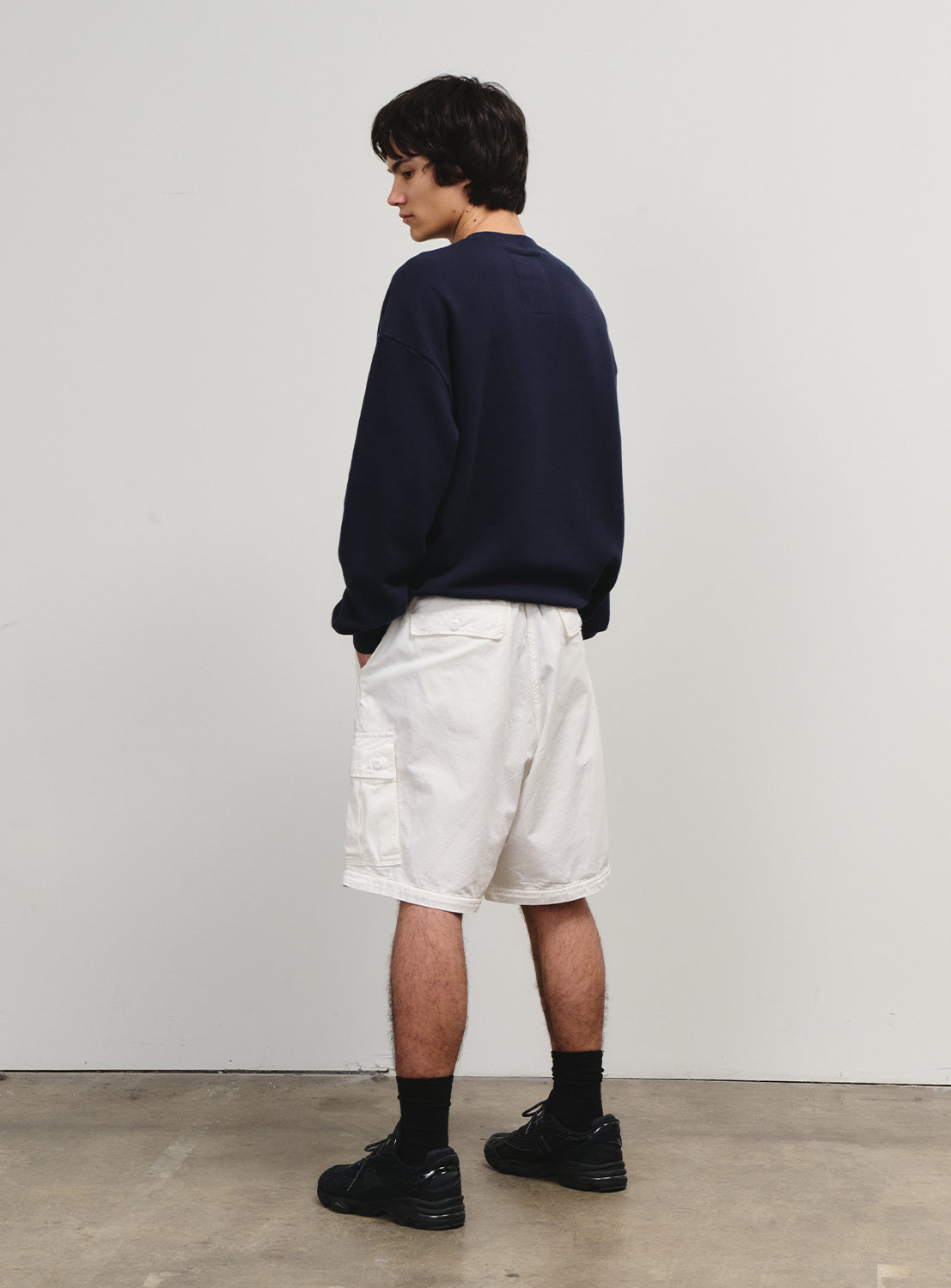 Side view of a model in white shorts, showcasing the nostalgic and youthful feel of the collection.