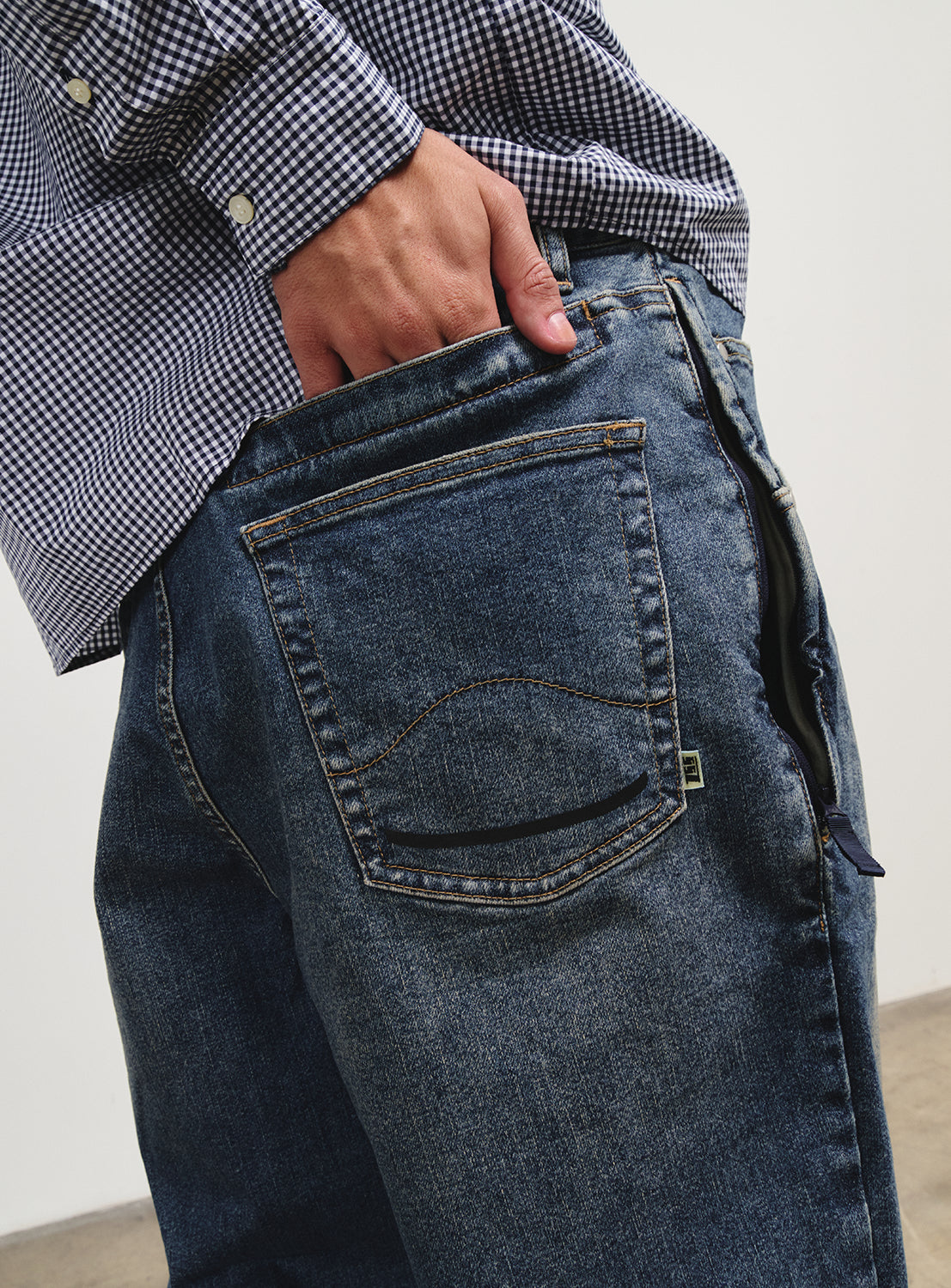 Close-up of the denim pants, showing a discreet pocket.