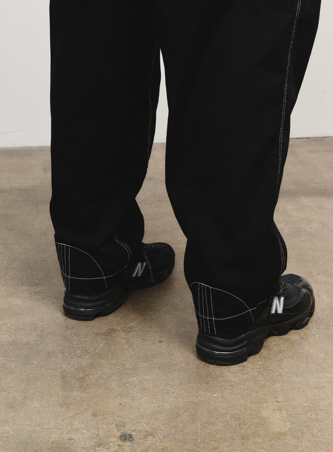 Close-up of the black V4N5 Pants highlighting the back ankle white stitching.