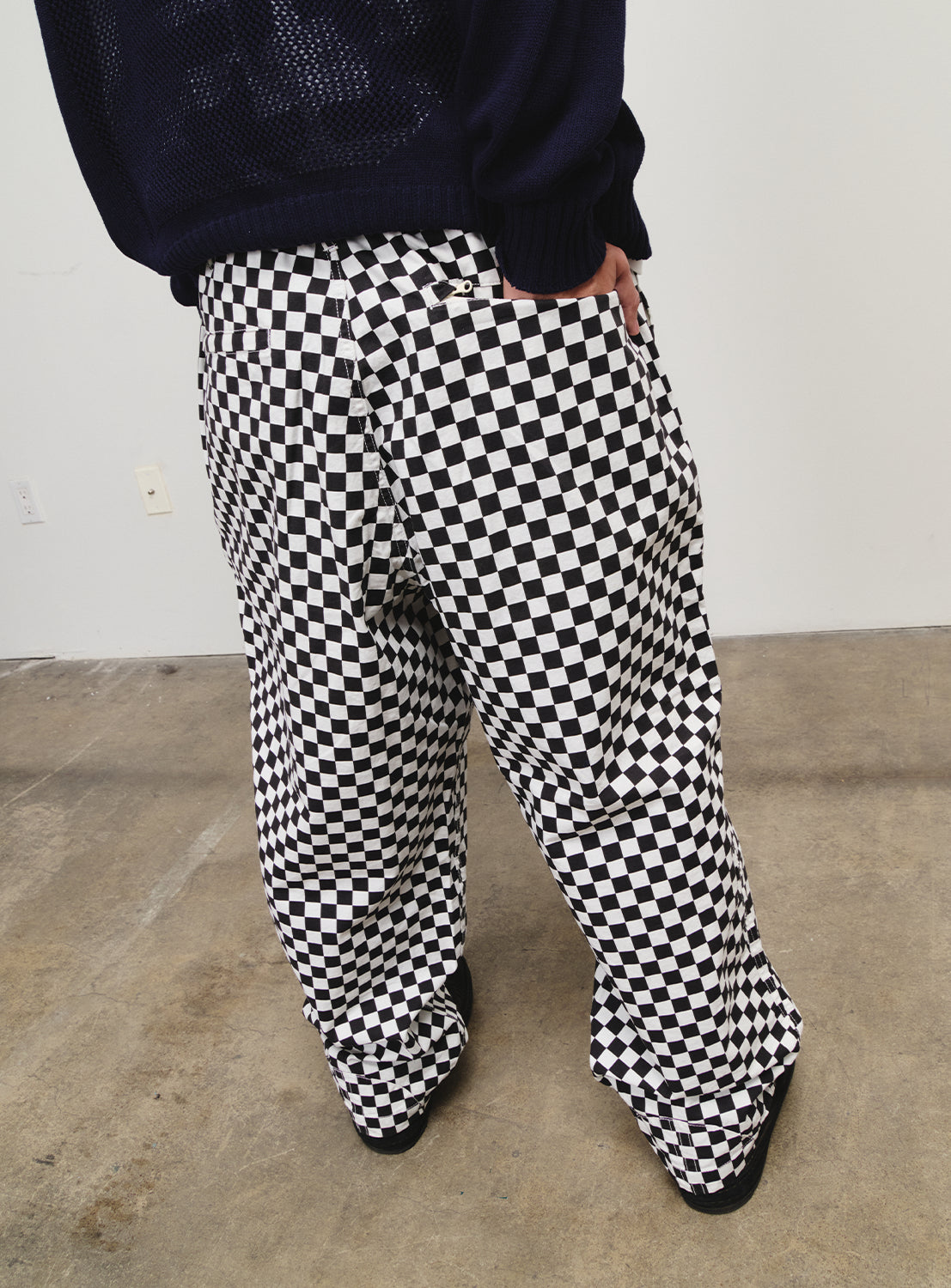 Side view of a model in black and white checkered pants.