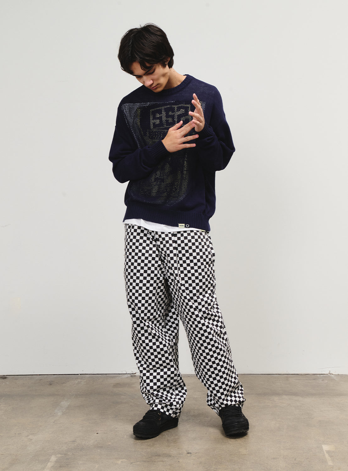 Full body shot of a model in checkered pants, a standout piece for skate and surf-inspired styling.