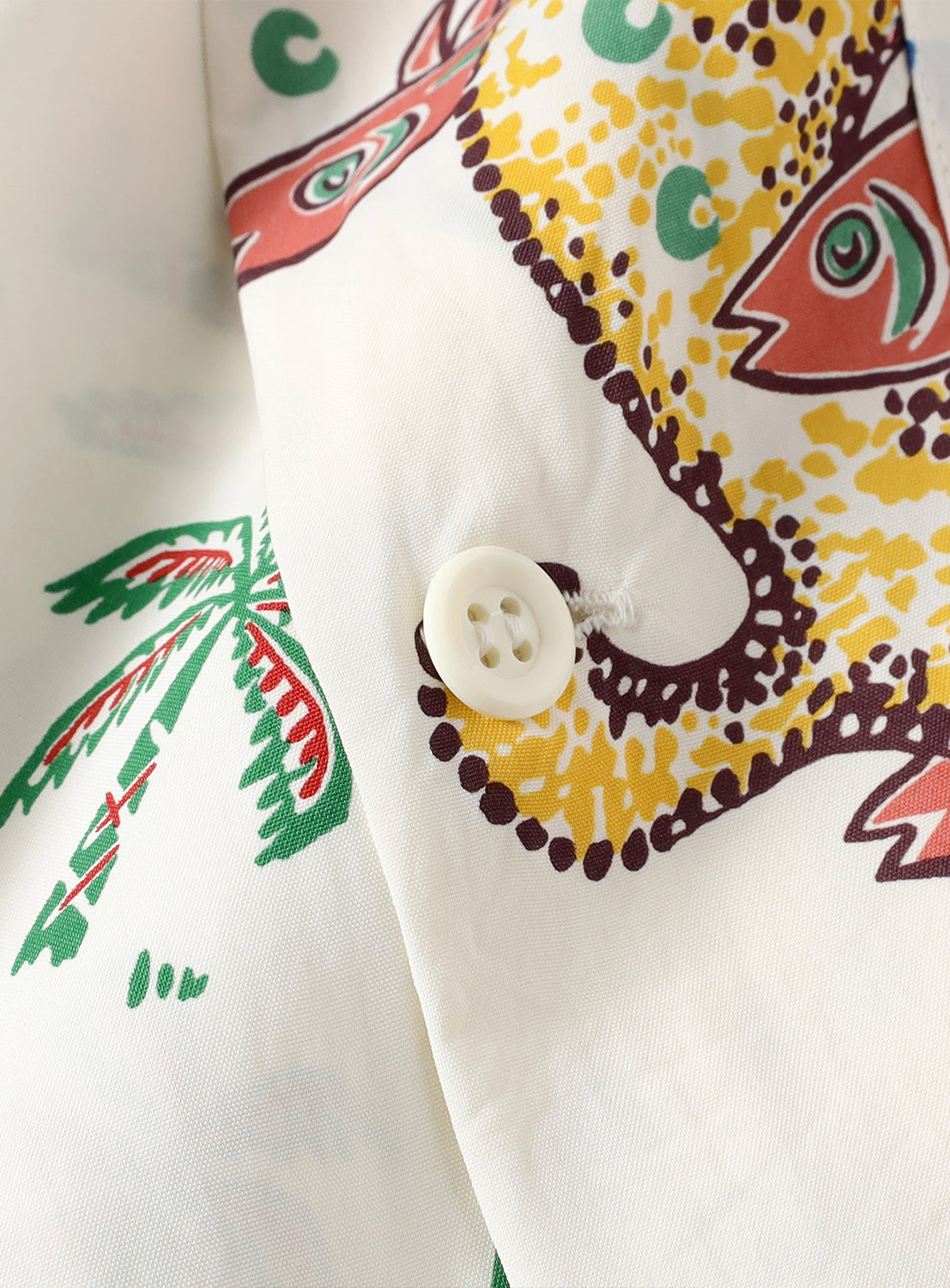 Close-up of a fabric with colorful patterns and a white button.