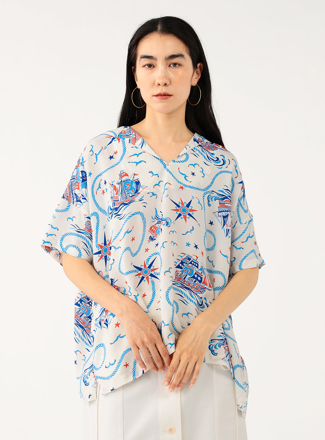 Full body shot of a model wearing a white patterned shirt, styled with a casual outfit.