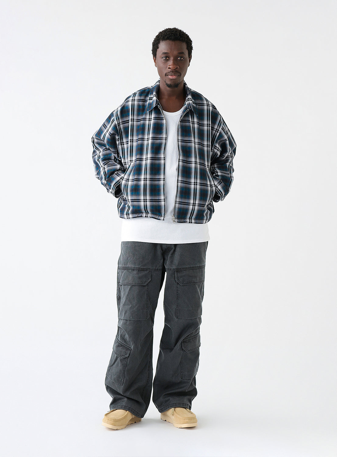 A full body view of a model wearing a navy blue and white checkered blouson jacket with a collar and front pockets.