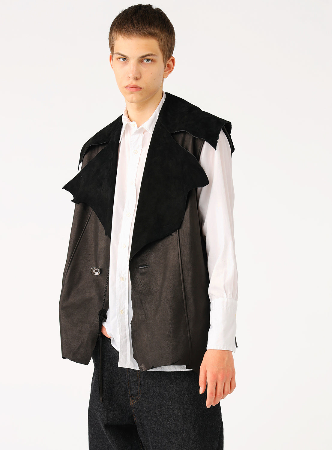 Model wearing a black leather vest over a white shirt, showcasing the contemporary silhouette and suppleness of the Ezo deer leather.