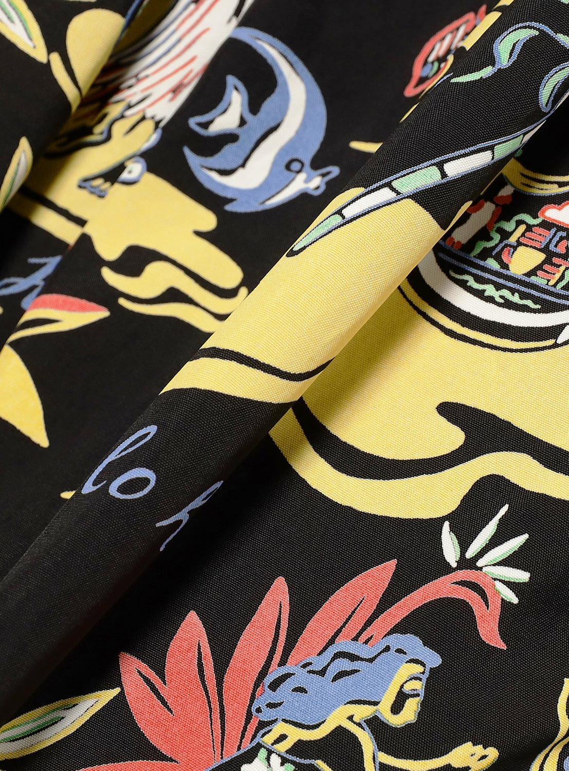 Black skirt fabric, revealing the intricate island and wave-like pattern in yellow, red, and blue.