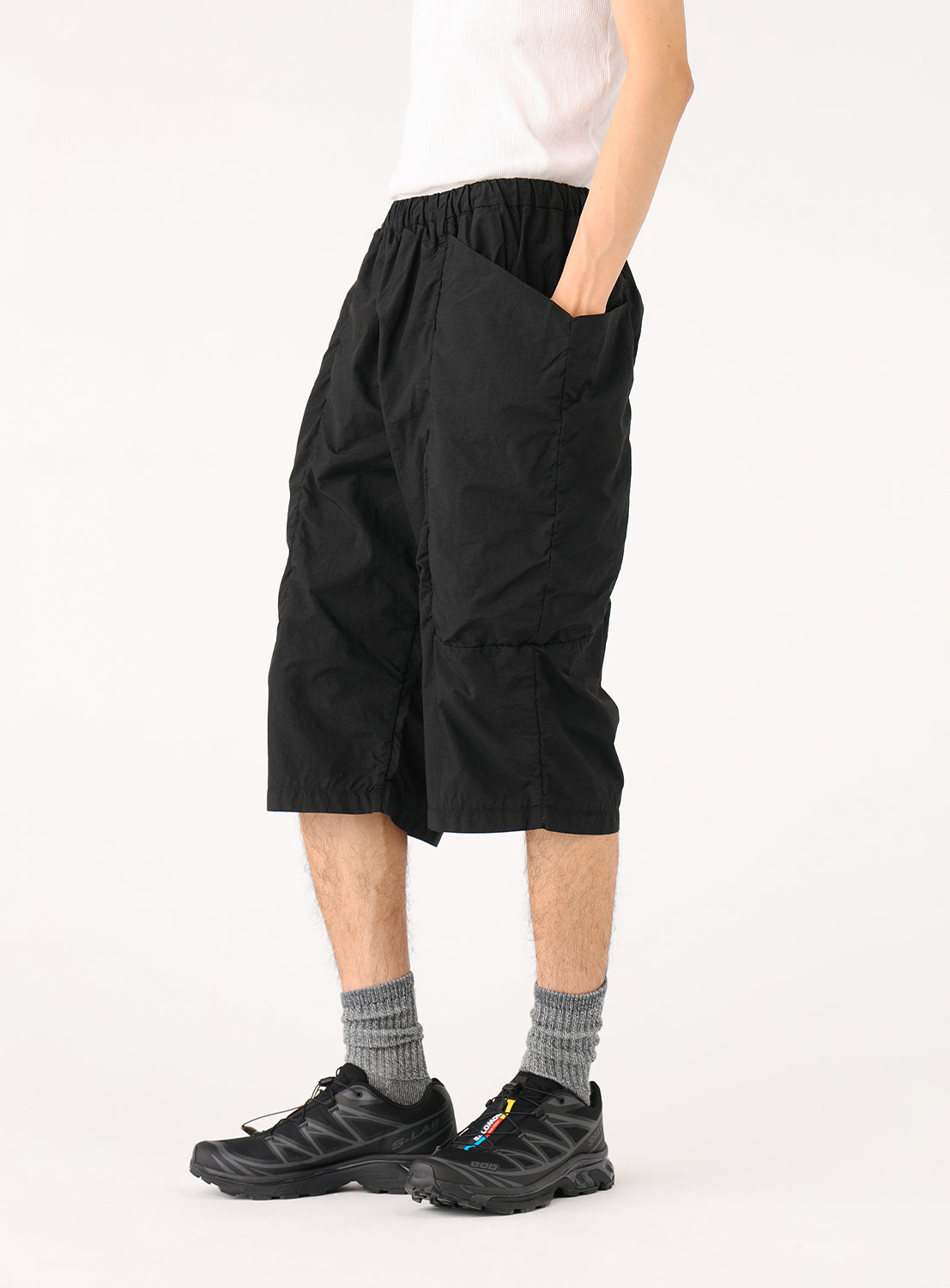 Side view of a model in black PACKABLE shorts, showing a clean silhouette that conceals their utility.